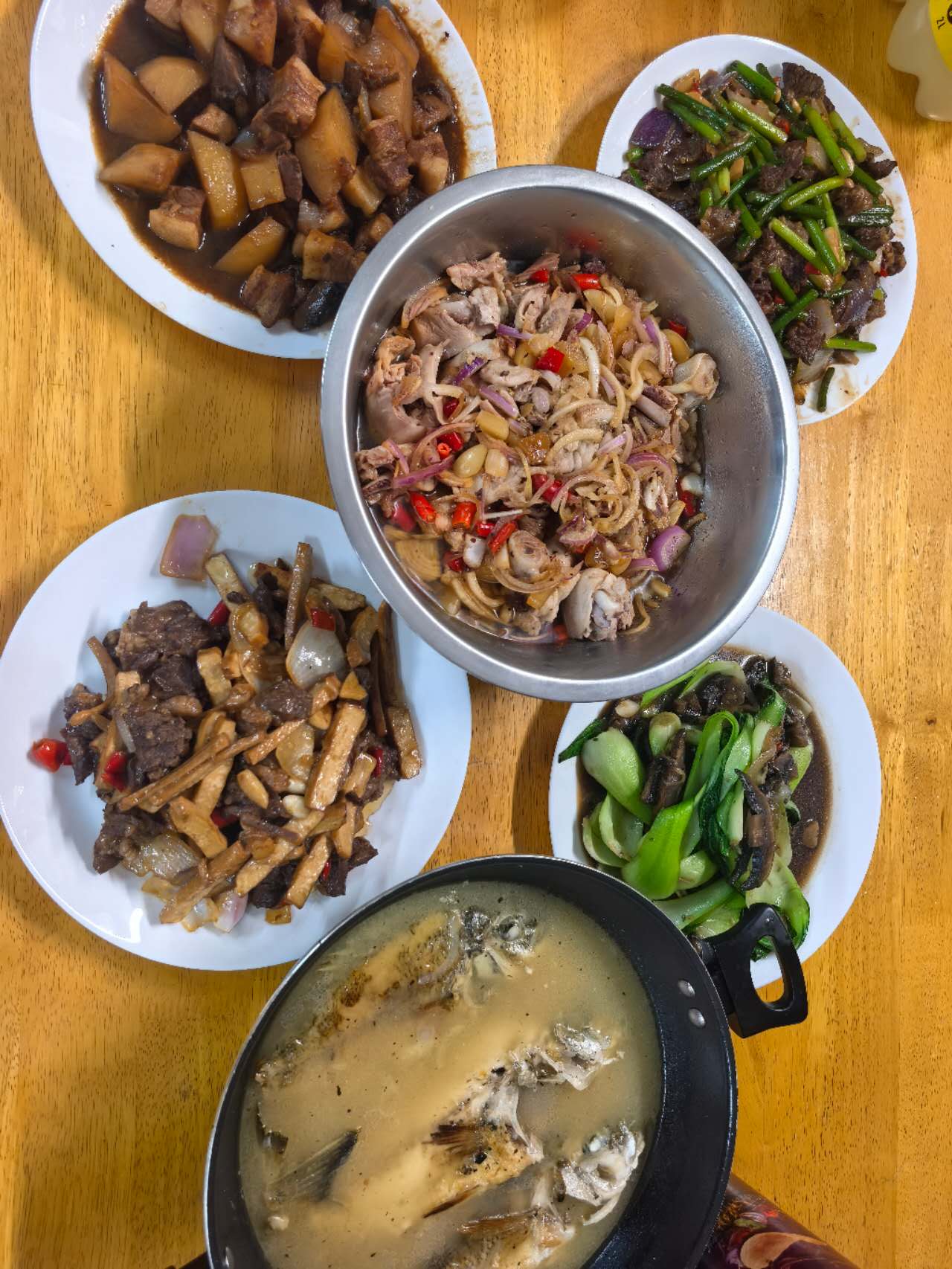 A feast of home-cooked Chinese dishes including braised pork and stir-fry